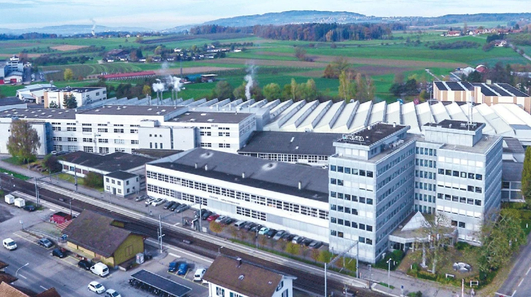 WORKPRO headquarters complex in Switzerland with office buildings and rows of factory roofs, seen from above WORKPRO headquarters complex in Switzerland with office buildings and rows of factory roofs, seen from above